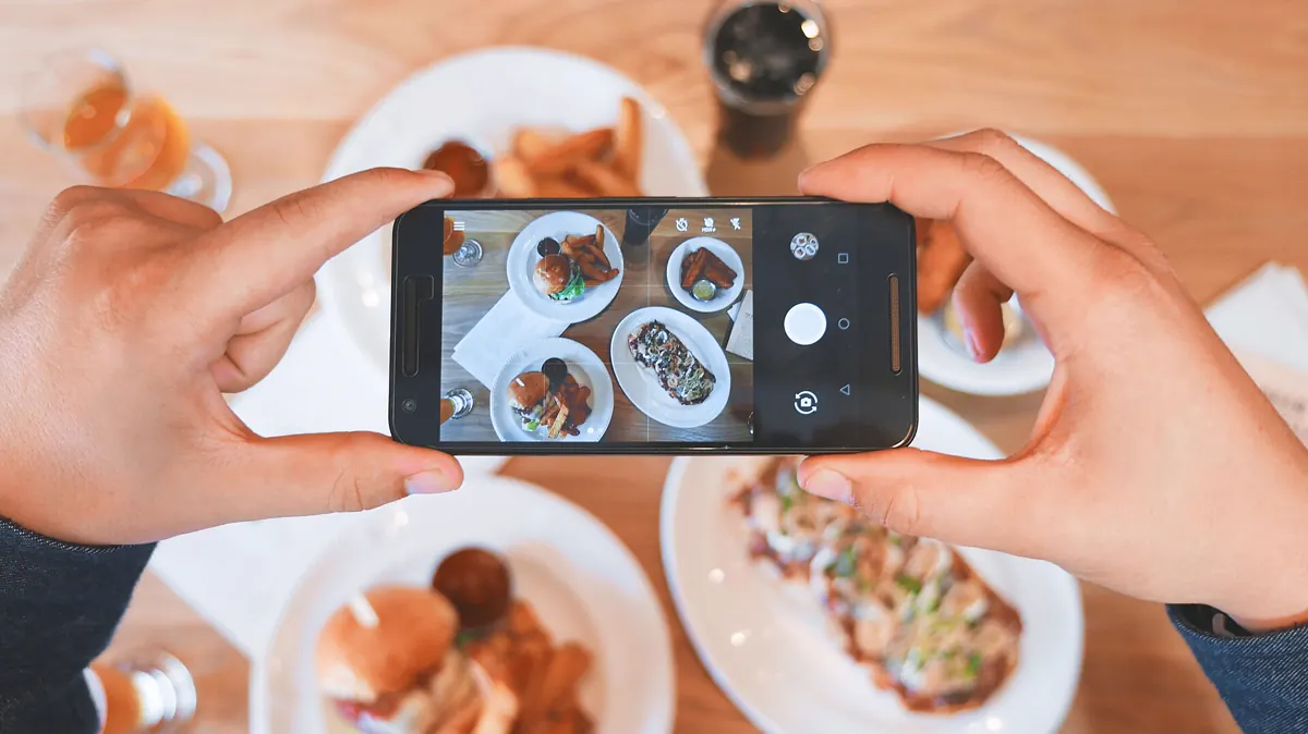 A person photographing media with a smartphone camera